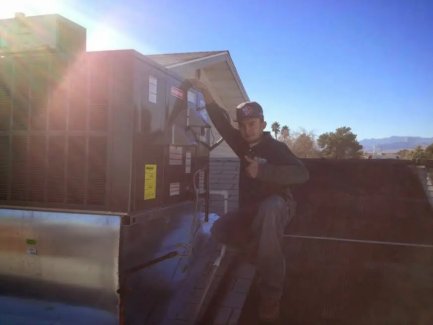 HVAC technician performing AC Tune-Up on a rooftop unit in Dumfries